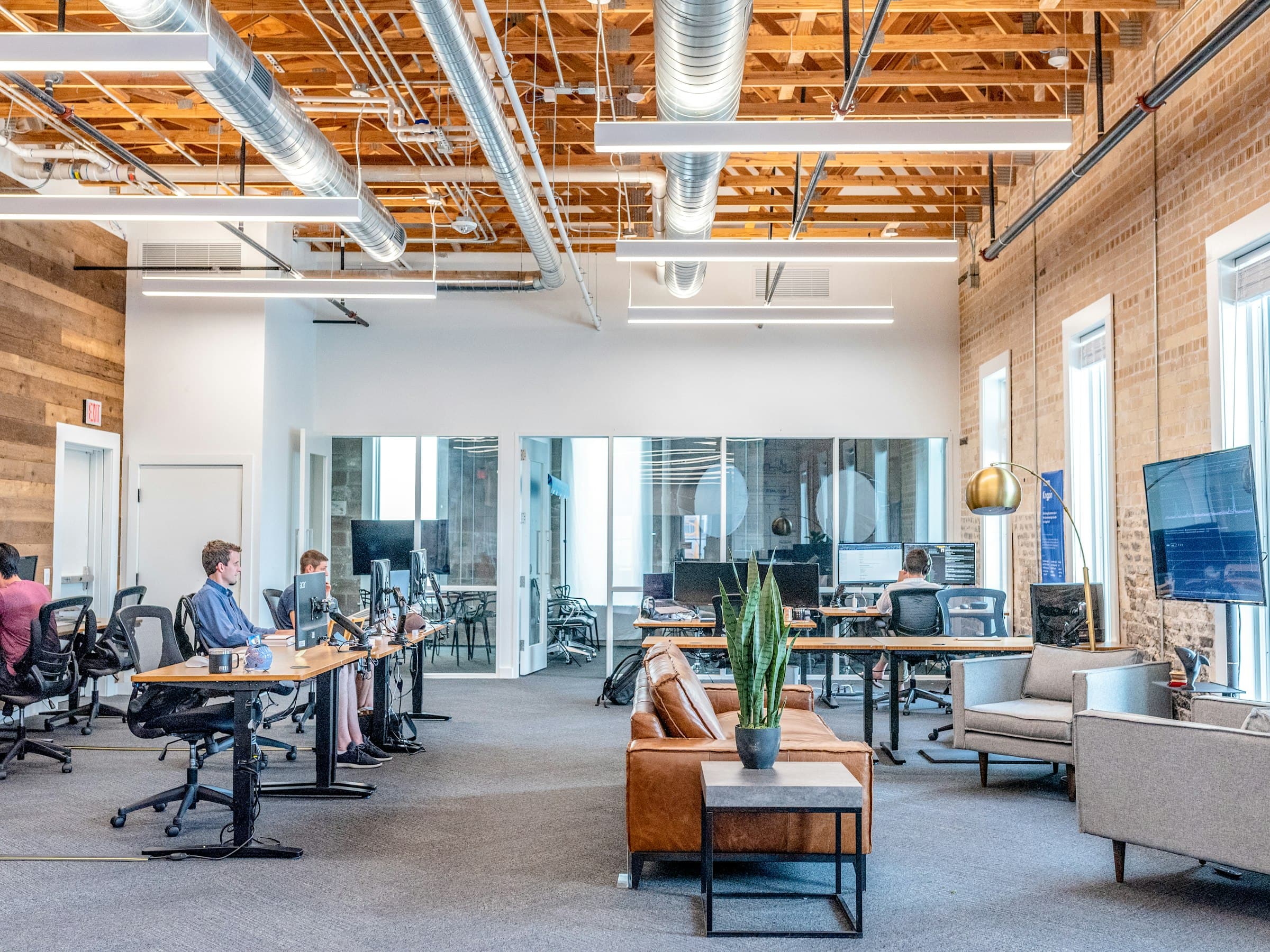 Open office bullpen with glass-walled rooms